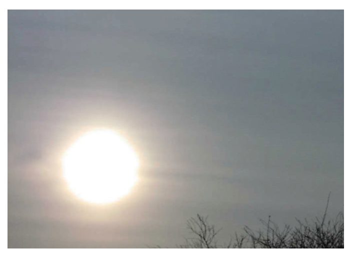 Photograph of altostratus with the sun visible as a dull disc.