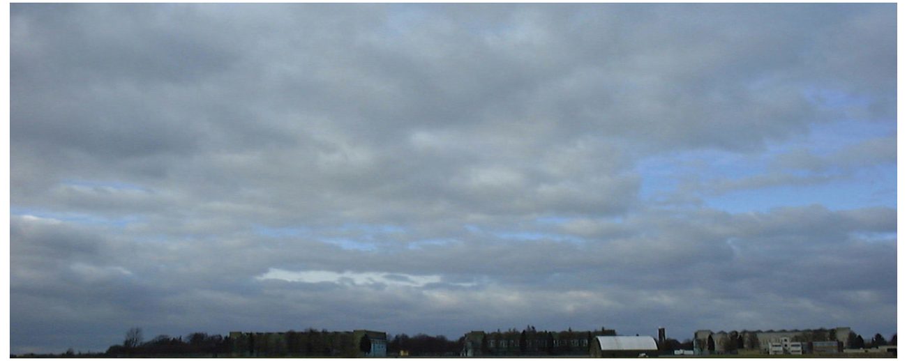 Photograph of a continuous layer of stratocumulus with dark patches.